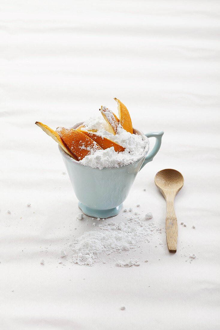 Orange peel with icing sugar in a cup
