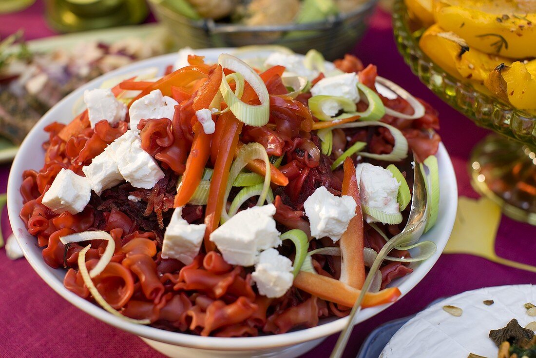 Salat mit roten Nudeln, Möhren, Lauch und Frischkäse