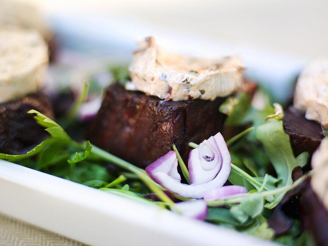 Beef steak with tomato and garlic butter on a bed of salad