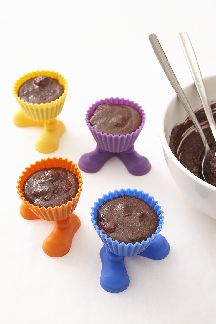 Chocolate cake dough in muffin cases with feet