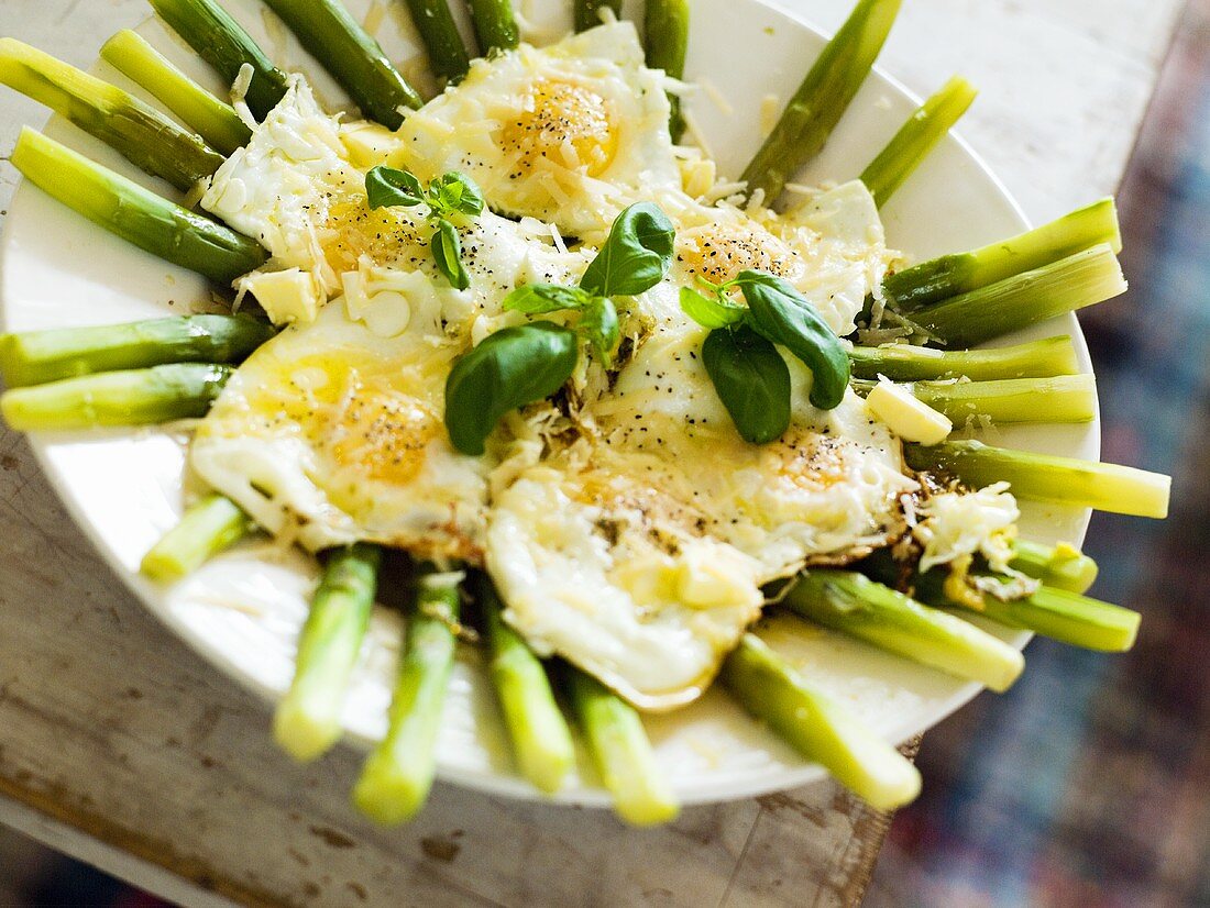 Grüner Spargel mit Spiegelei und Basilikumblättern