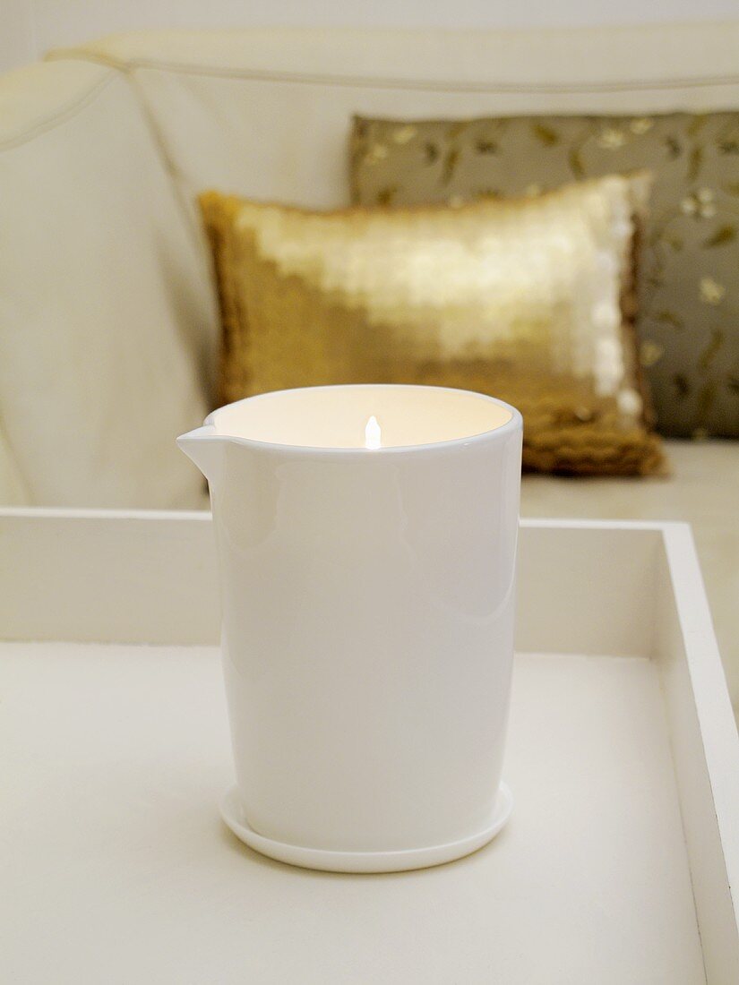 A scented candle in front of a sofa