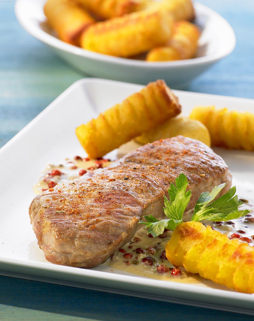Veal steak with red peppercorns and potato croquettes