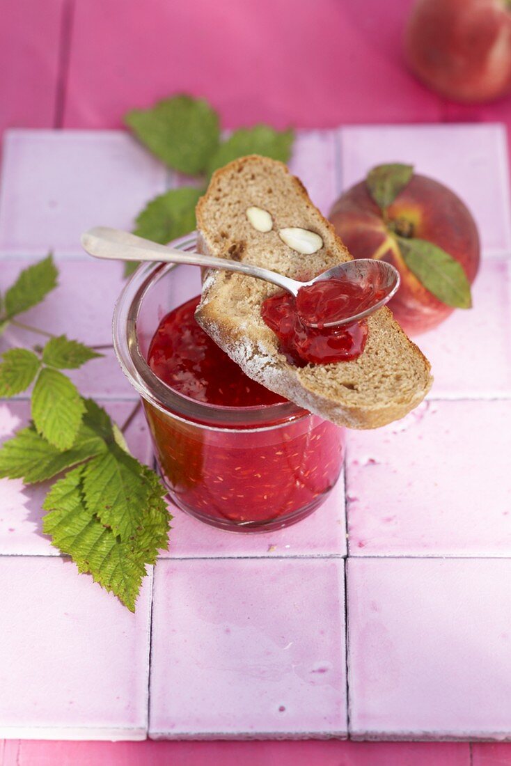 Raspberry and peach jam with a slice of almond bread