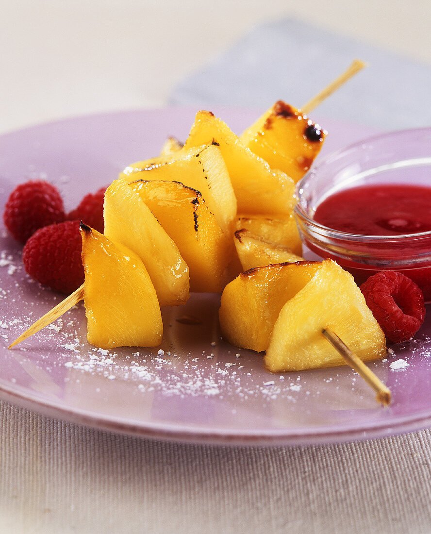 Fried pineapple & mango skewers with raspberry puree & raspberries