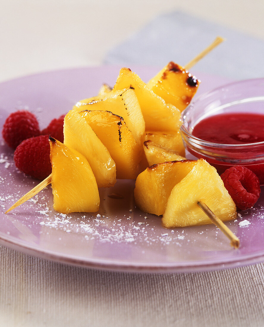 Gebratene Ananas-Mango-Spieße mit Himbeermark und Himbeeren