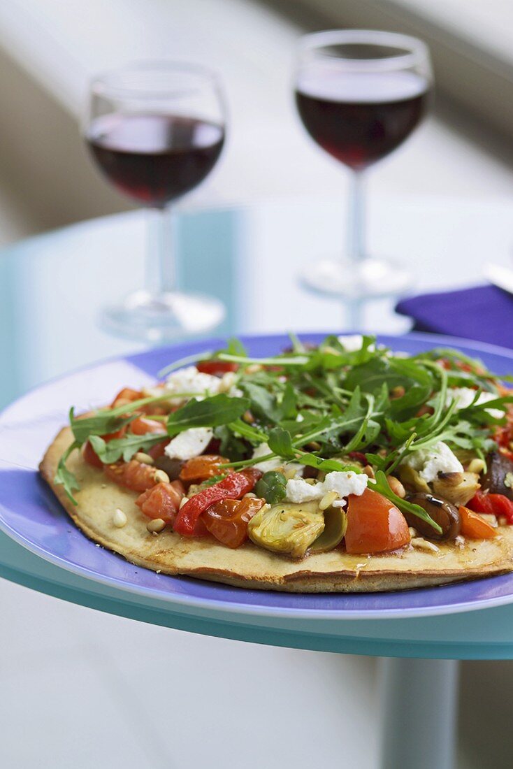 A vegetarian pizza with two glasses of wine
