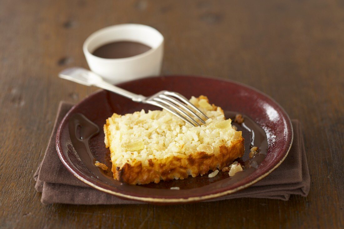 Slice of baked rice loaf with pineapple, ginger & chocolate sauce