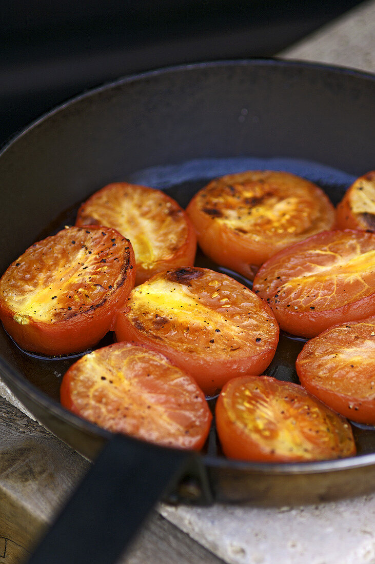Fried tomato halves in a frying pan