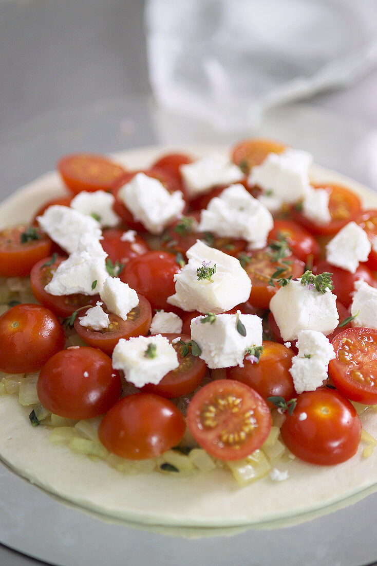 Ungebackenene Pizza mit Tomaten und Mozzarella