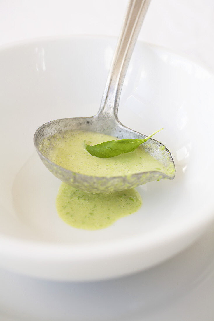 Pea cream sauce with basil in a sauce spoon