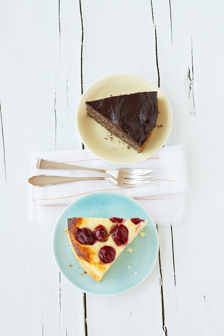 A piece of cherry cheesecake & a piece of chocolate poppy seed cake