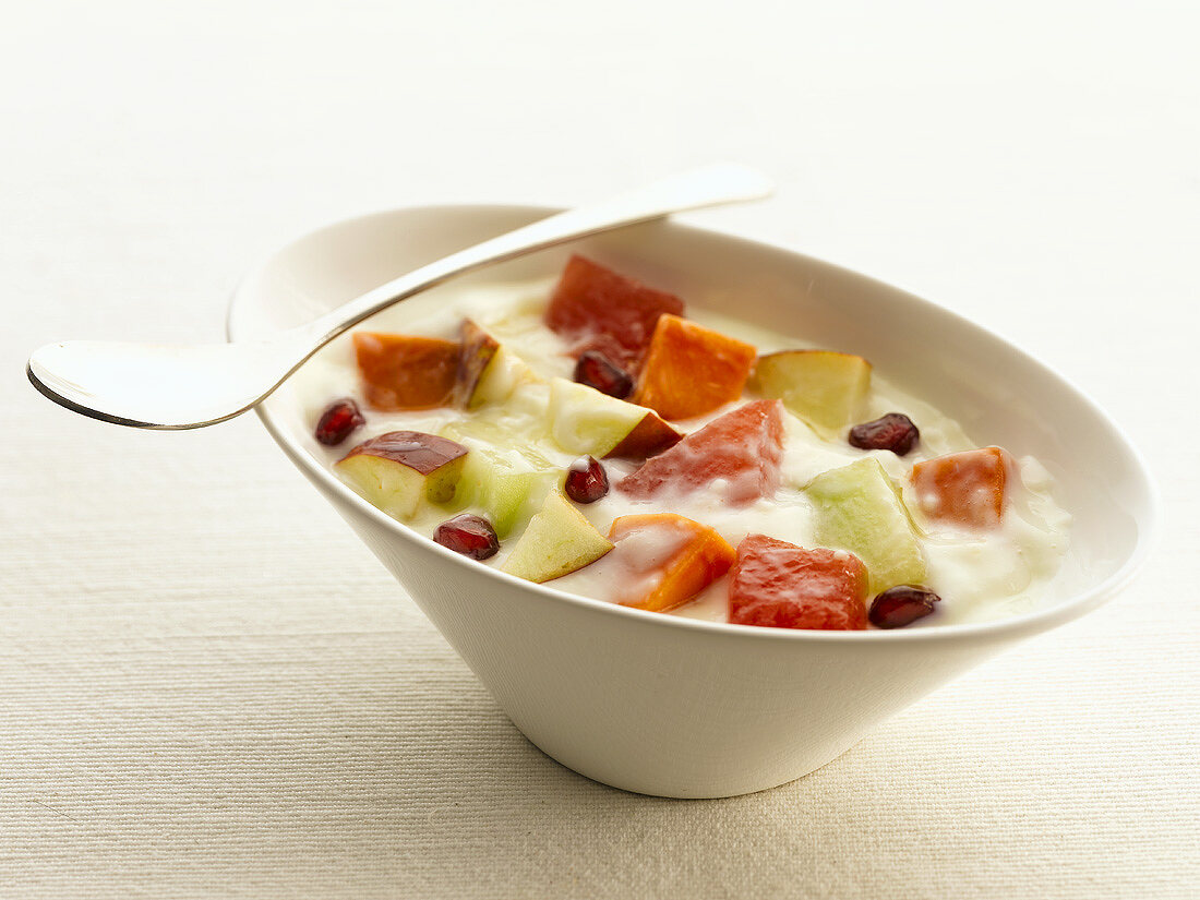 A bowl of fruit salad in vanilla cream