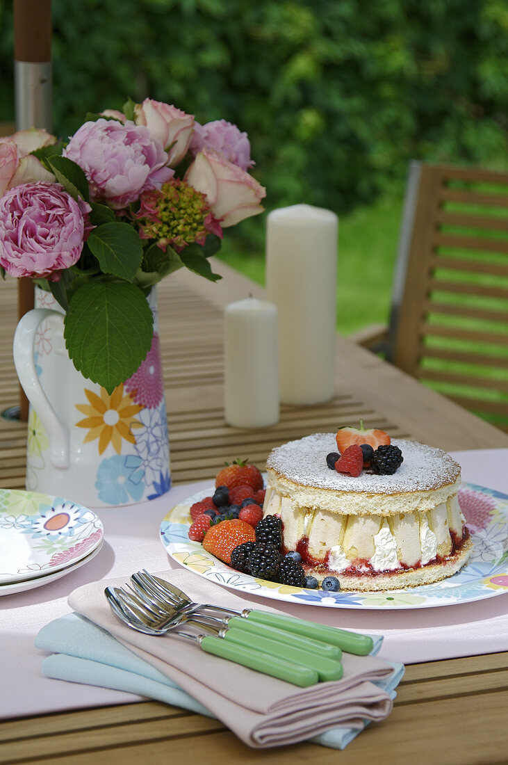 Sponge cake with cream and mixed berries out of doors