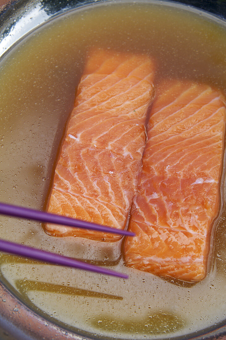 Two salmon fillets in fish stock