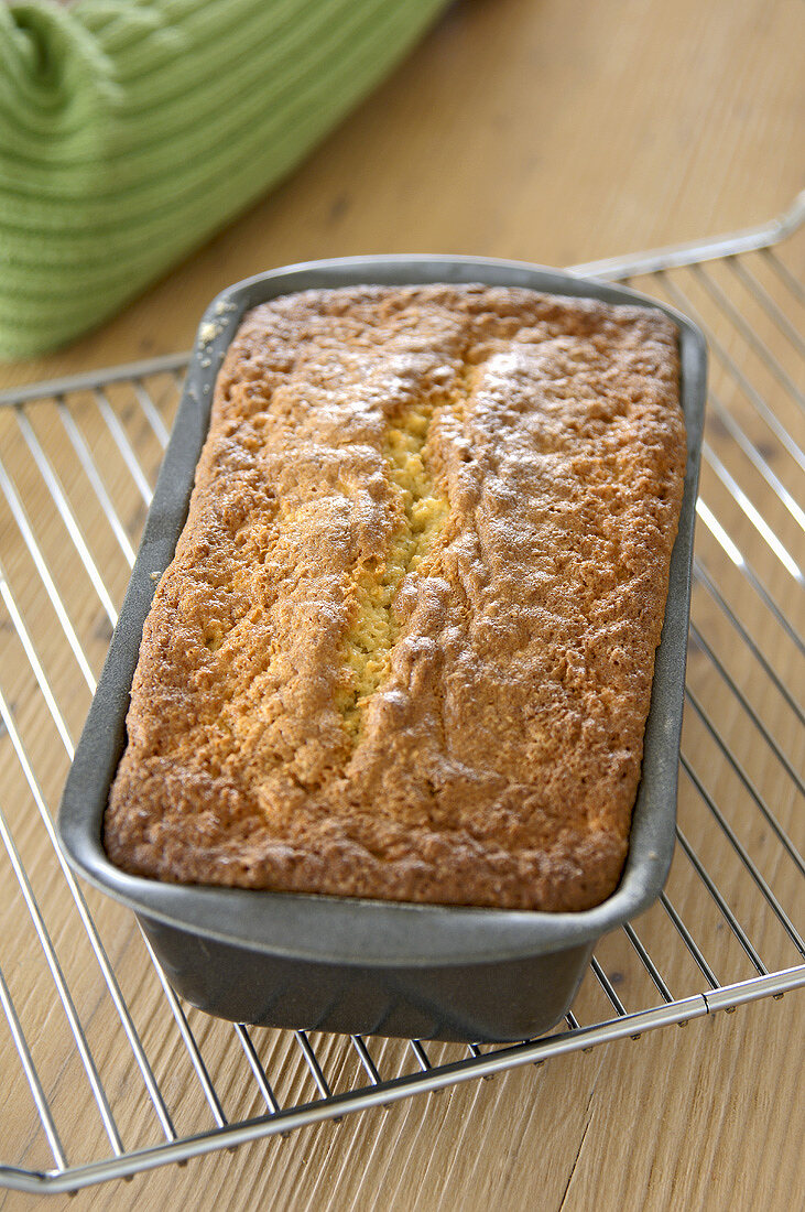 A spiced apple cake in a loaf tin on a cake rack