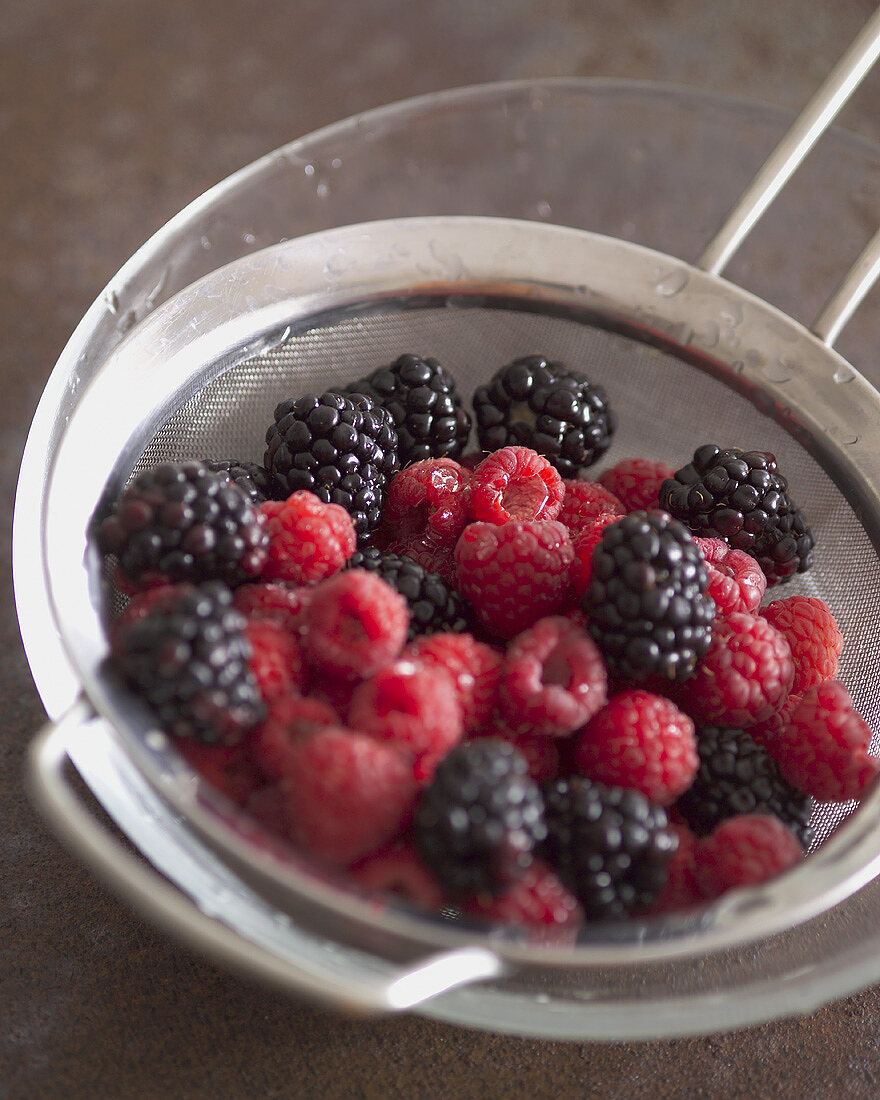 Gewaschene Brombeeren und Himbeeren in einem Sieb