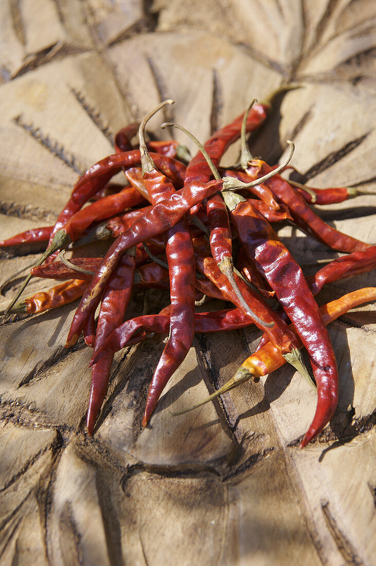 Several dried chillies on wooden background