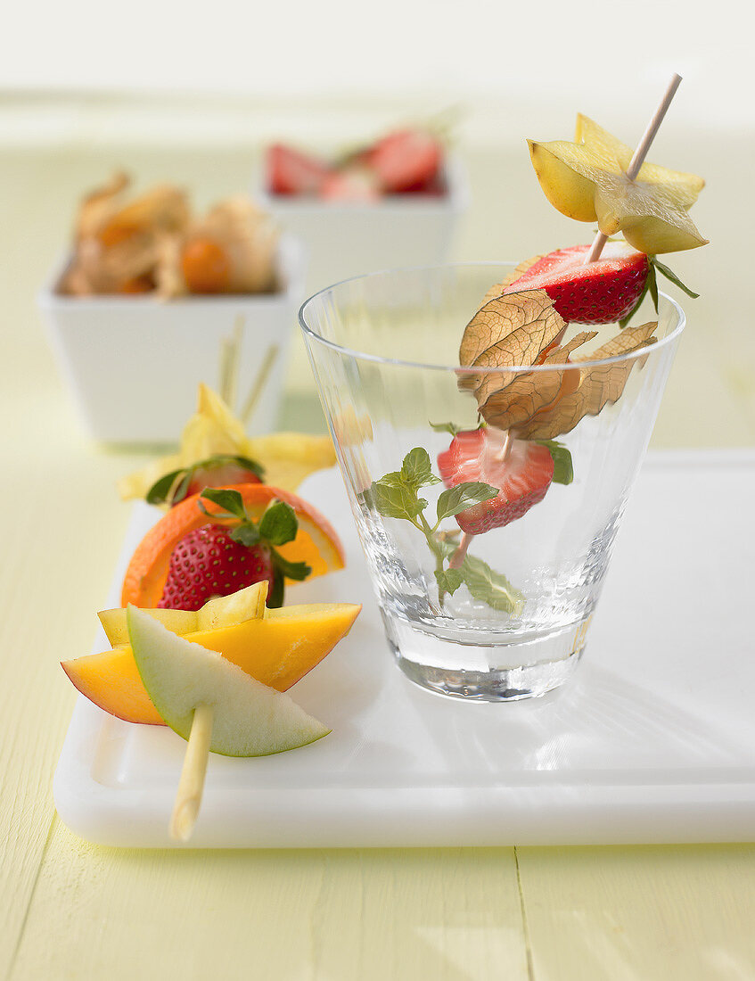 Two fruit skewers with different fruits