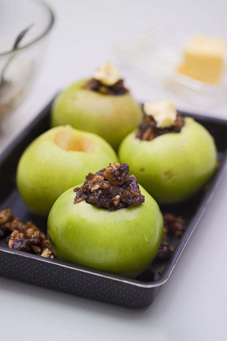 Four apples stuffed with raisins and nuts ready for baking
