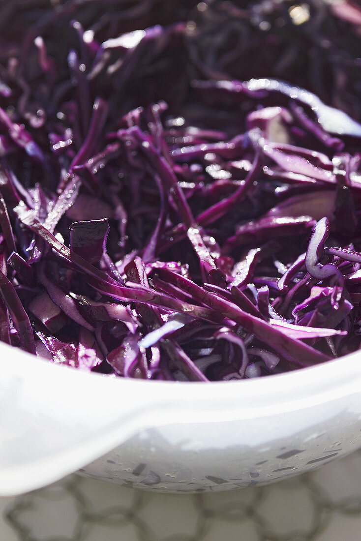 Shredded red cabbage in a plastic sieve