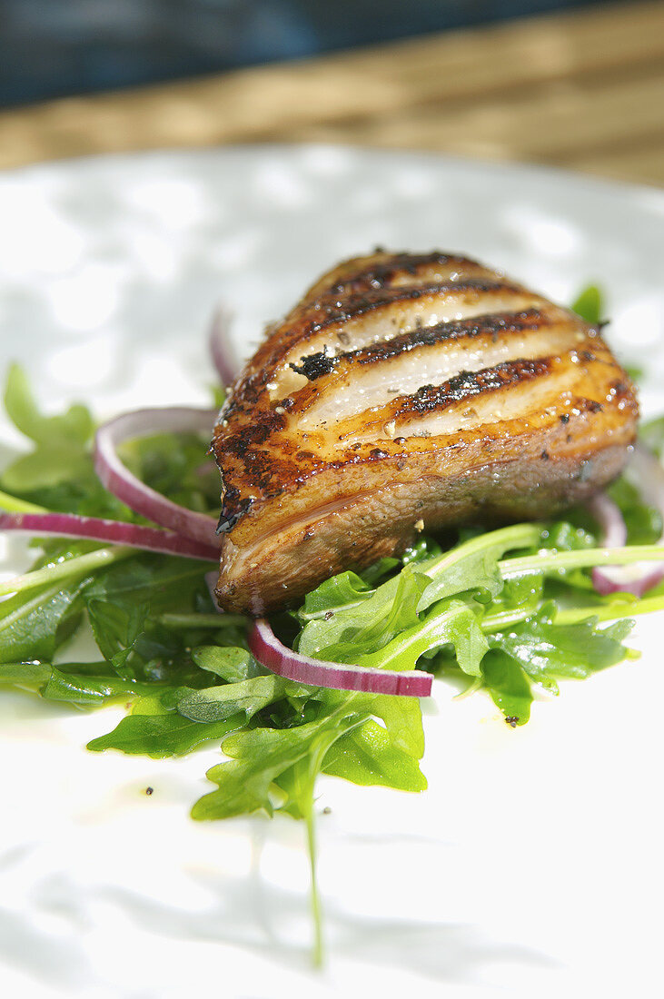 Marinated and halved, grilled duck breast on rocket