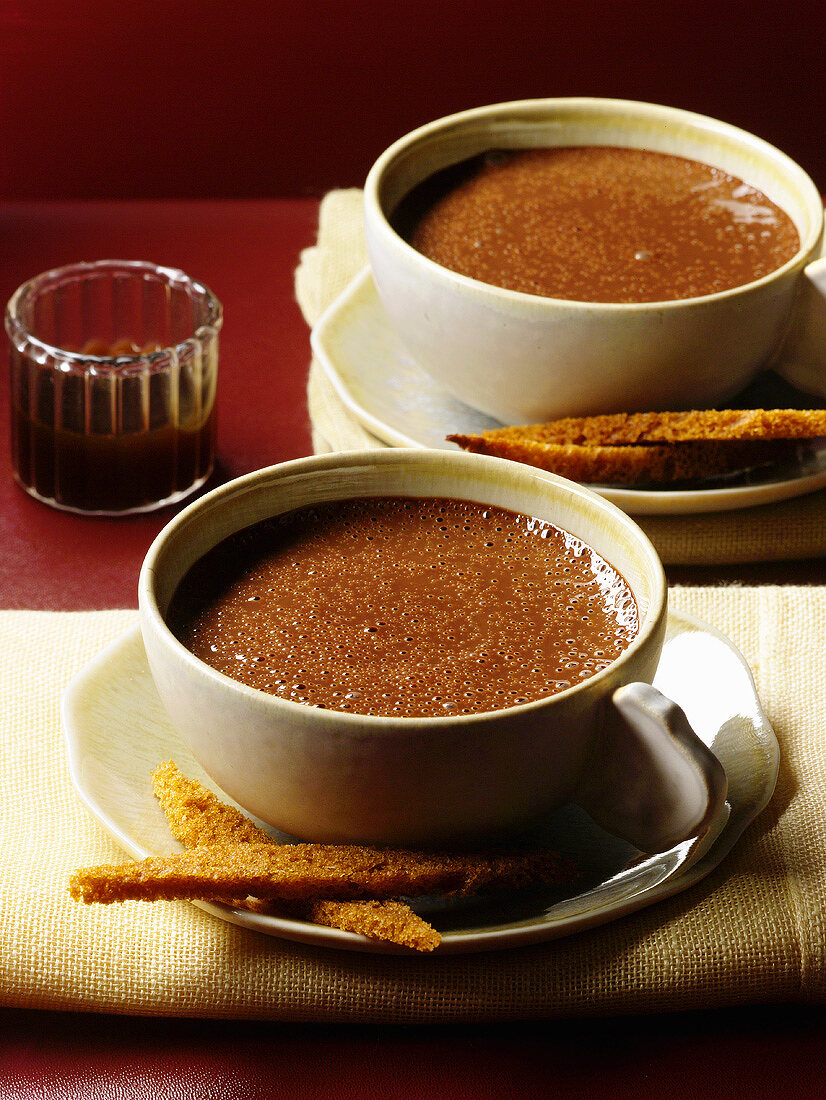 Two cups of hot chocolate with spice cake fingers