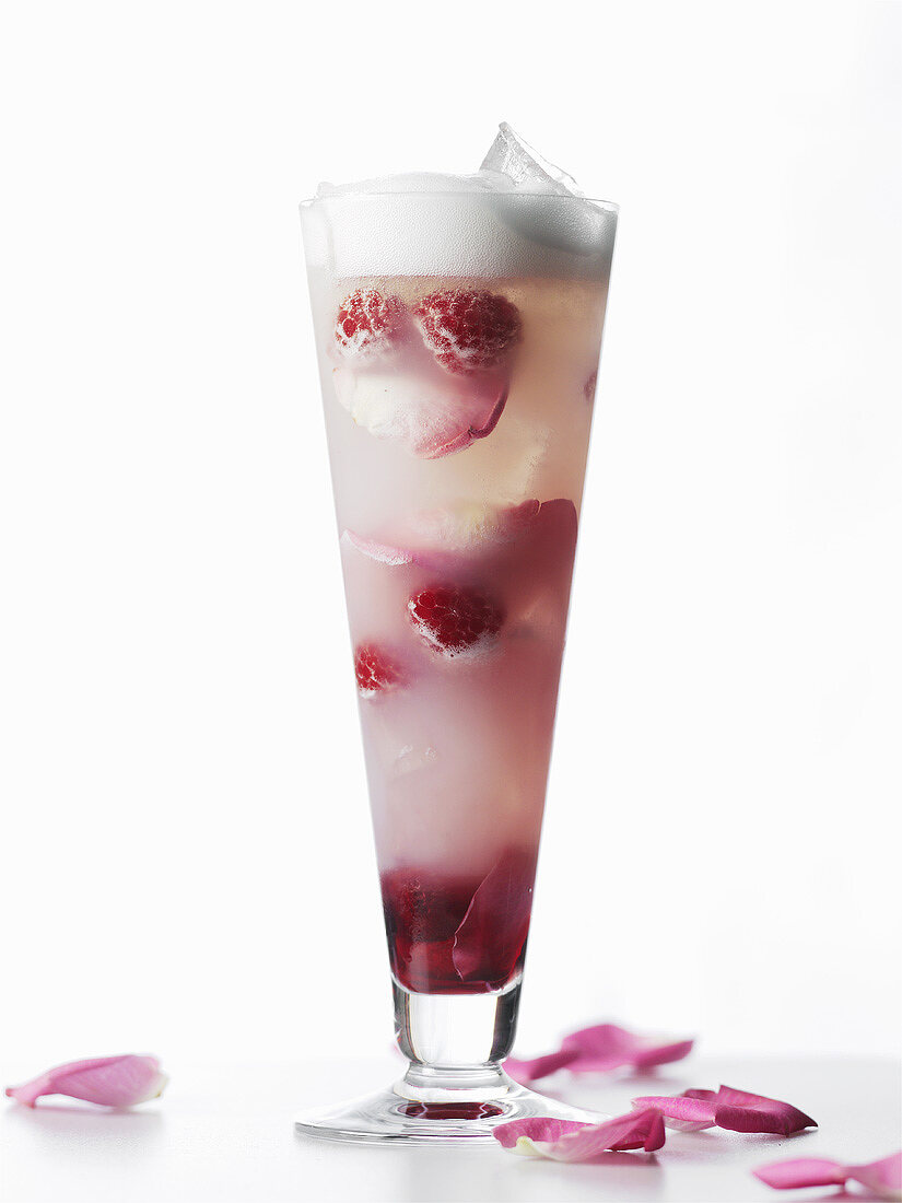 Ein Champagner-Cocktail mit Himbeeren und Rosenblättern