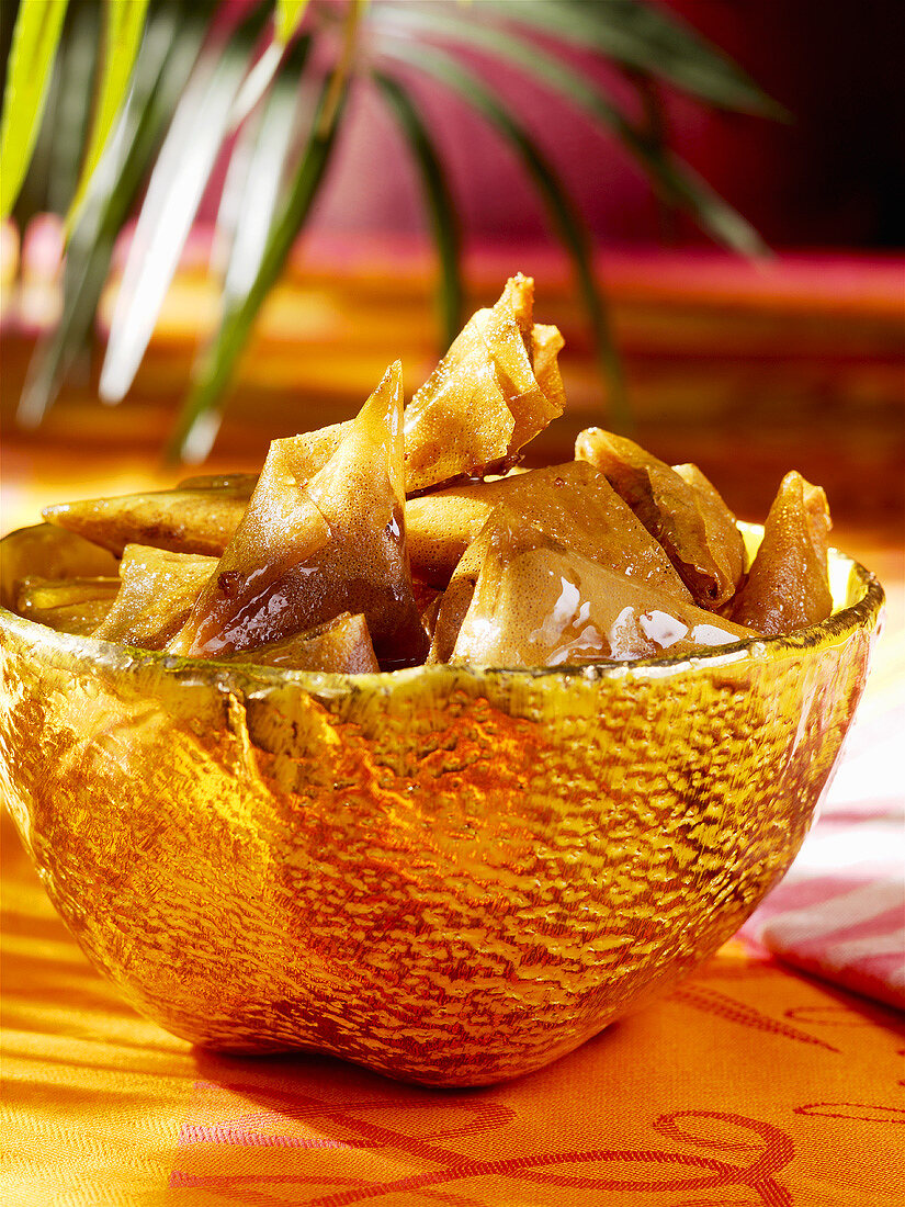 Briouats with honey in a bowl (Moroccan pastries)