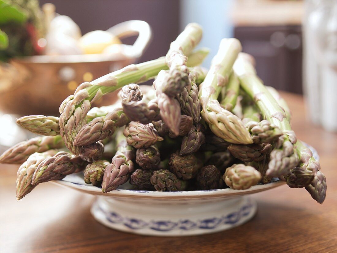 Green asparagus spears on a china plate