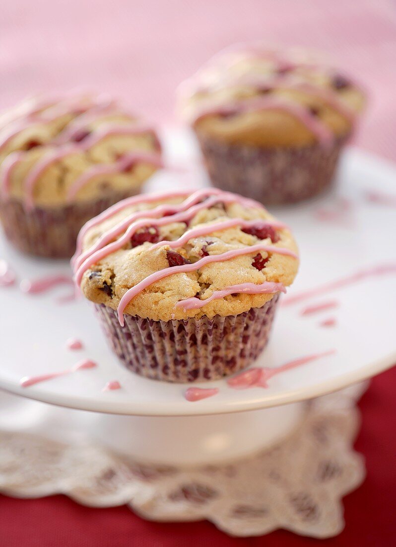 Three cranberry muffins with drizzle icing