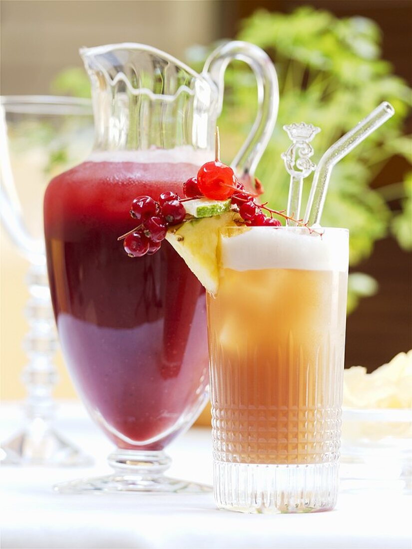 Two exotic fruit cocktails in carafe and glass