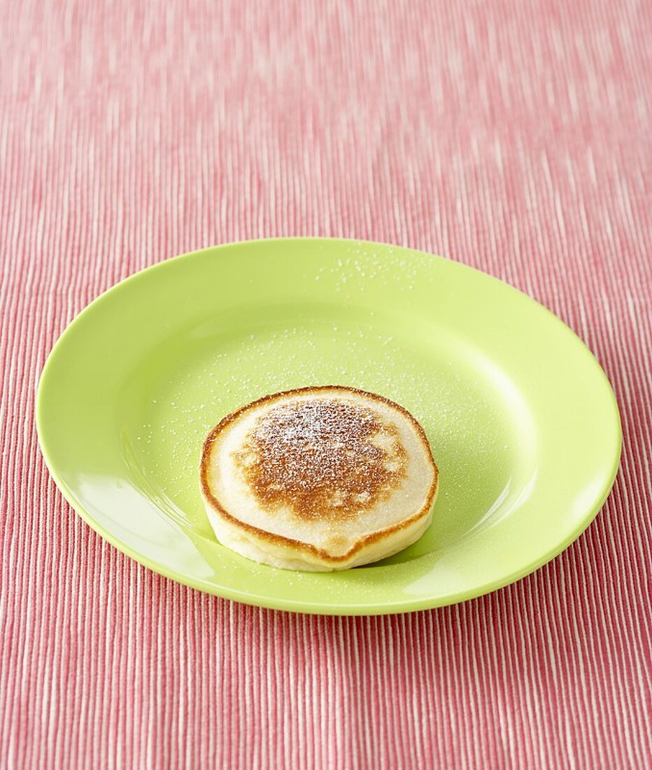 An apple pancake sprinkled with icing sugar