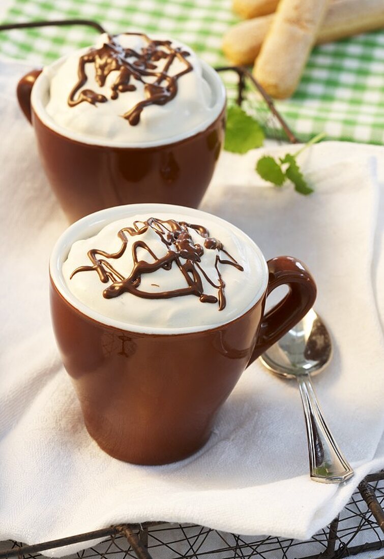 Cappuccino mousse with chocolate sauce in two espresso cups