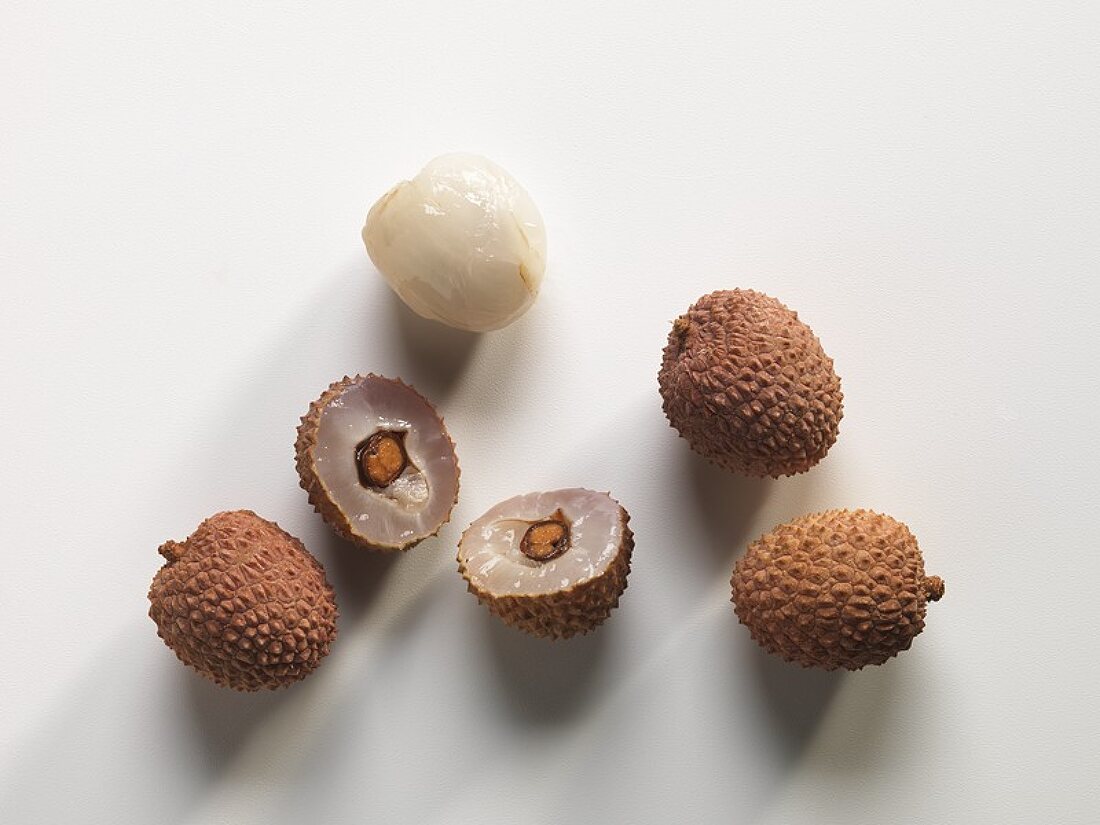 Lychees, three whole, one peeled and one halved