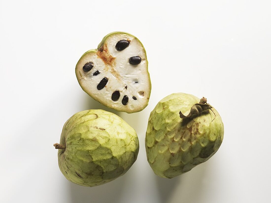 Cherimoyas, two whole and one halved