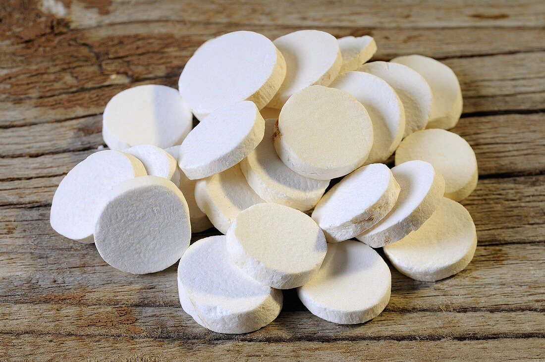 Slices of yam root on wooden background