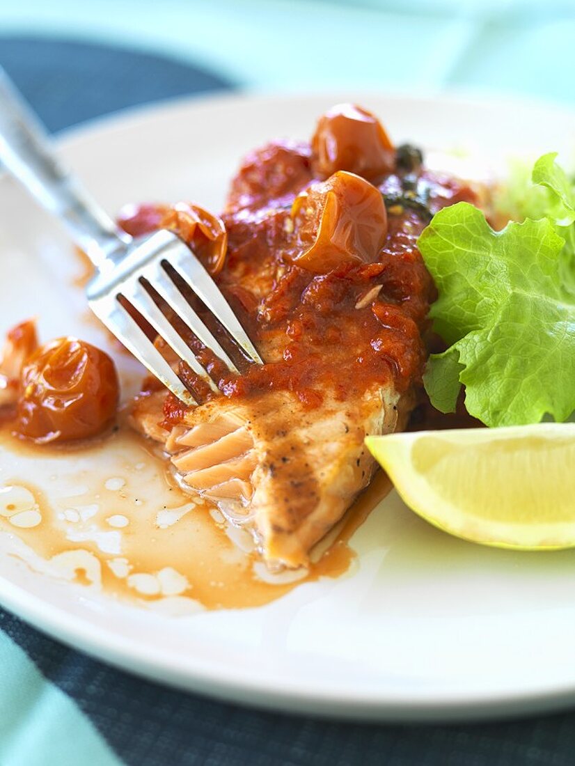 Salmon with pepper and tomato sauce and salad leaves