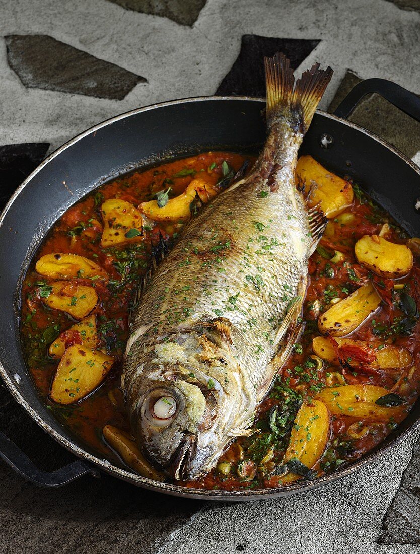Whole bream with marinade cooked in a frying pan