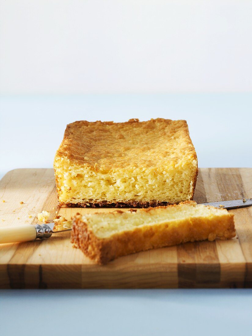 A partly sliced brioche on a chopping board