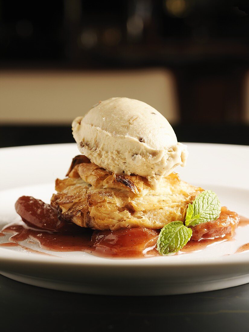 Filled pastry with walnut ice cream on plum compote