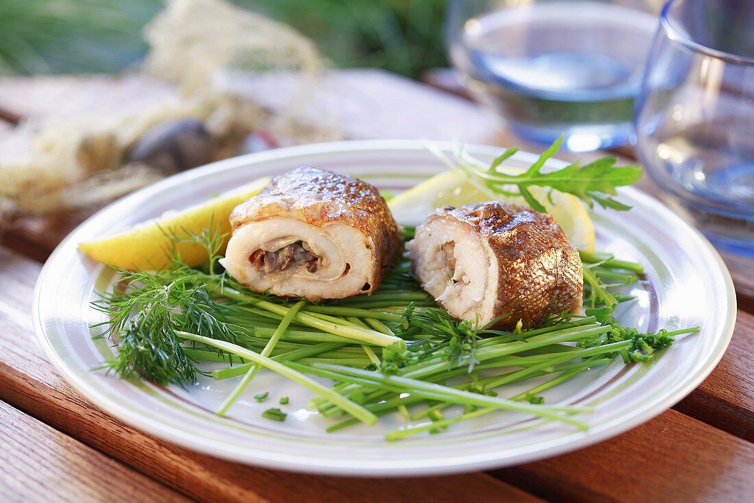 Gegrillte Fischröllchen auf Kräutern mit Zitrone