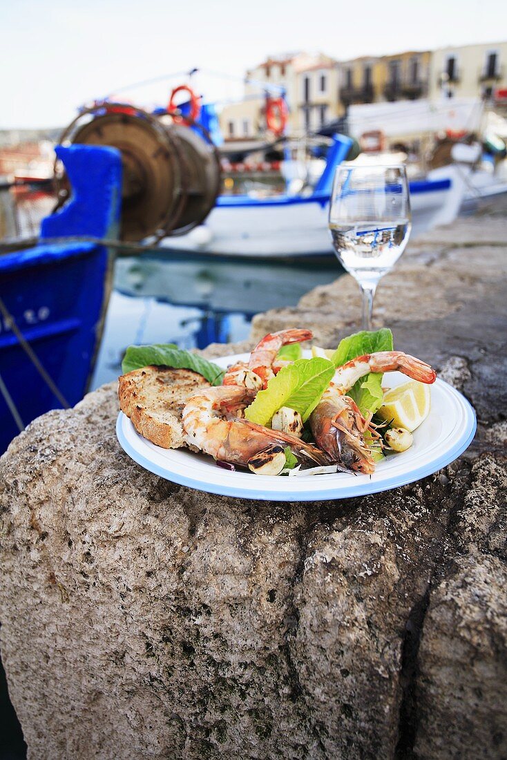 Grilled prawns with wine on a stone in a harbour