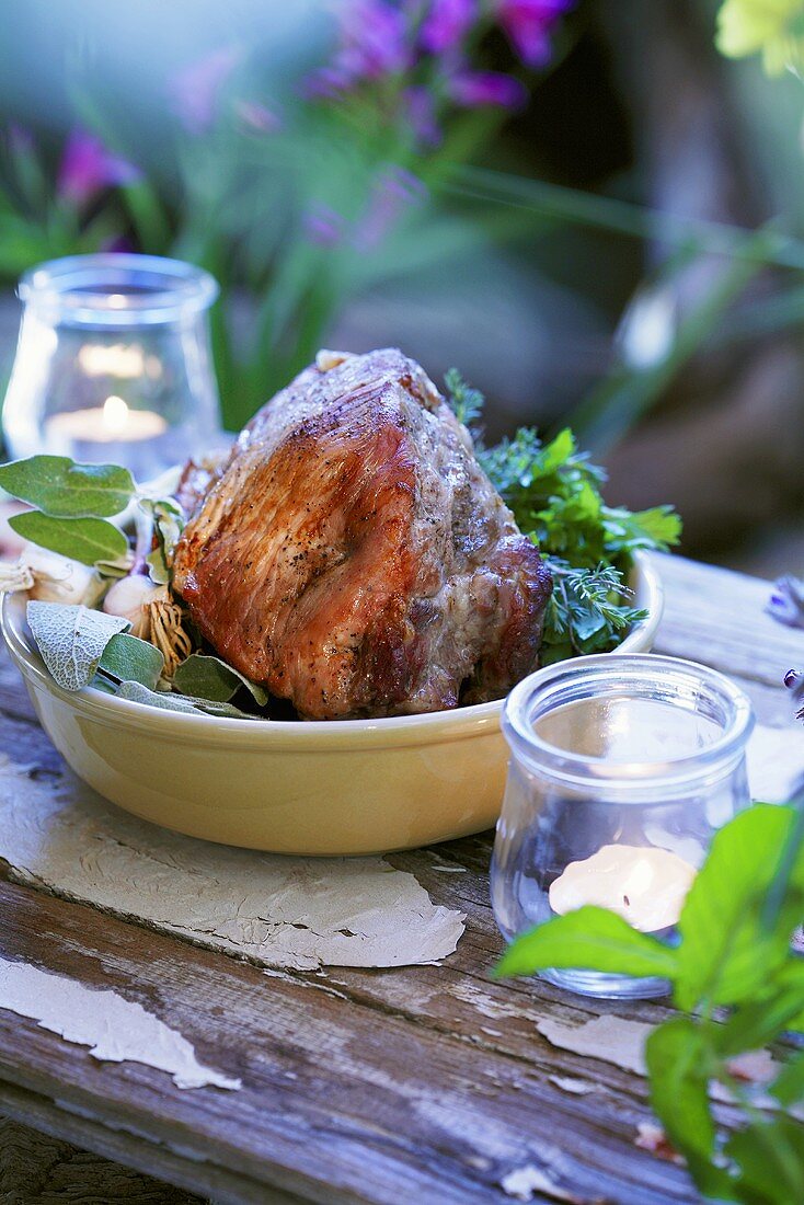 Schweinebraten auf Kräutern in einerm Schüssel im Freien