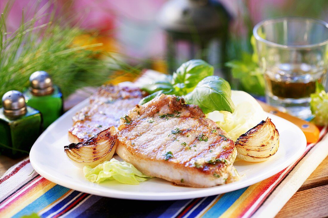 Grilled pork chops with onions on iceberg lettuce