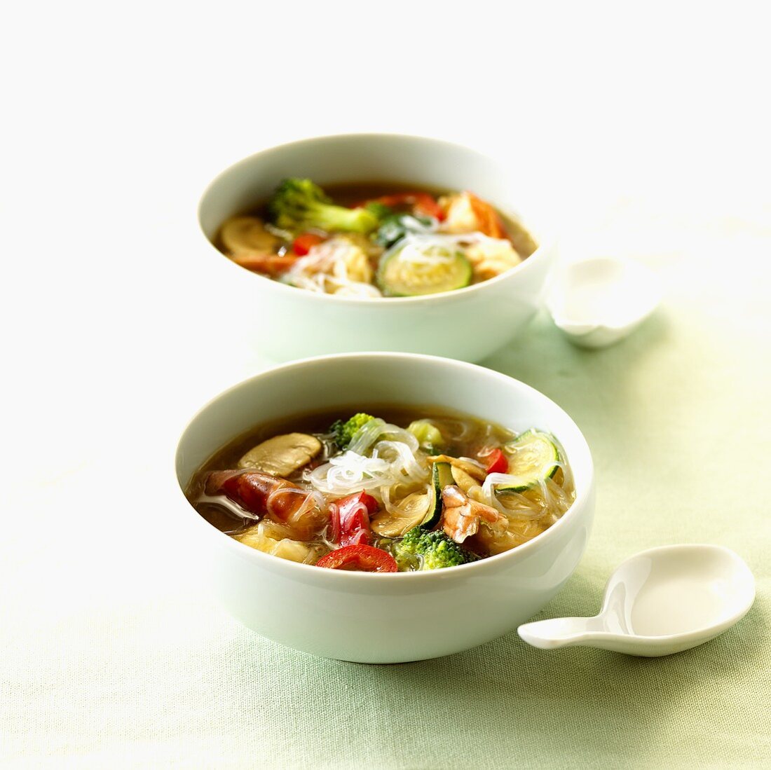 Two bowls of vegetable soup with prawns and glass noodles