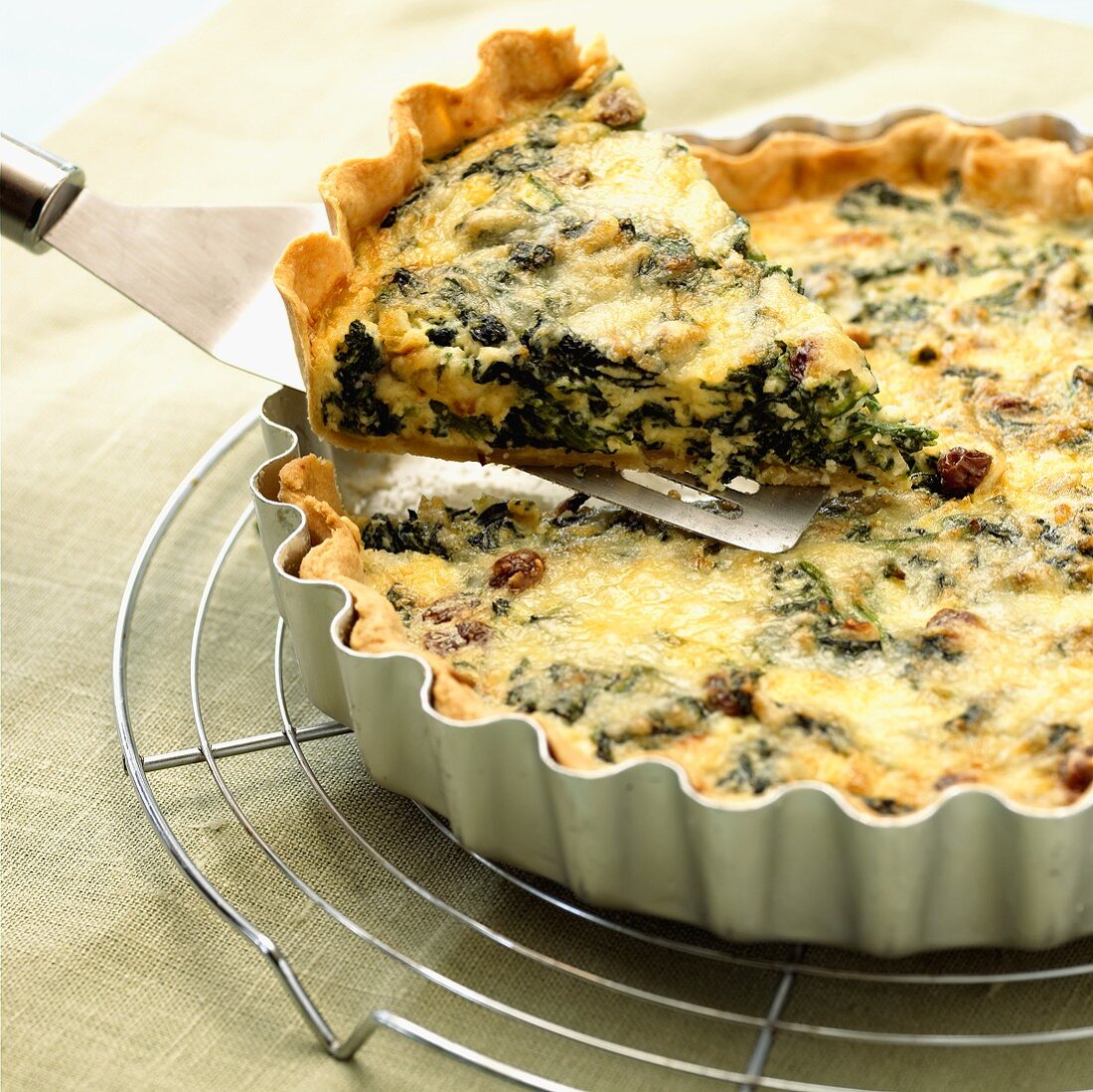 Spinach and cheese tart in the tin on a cake rack