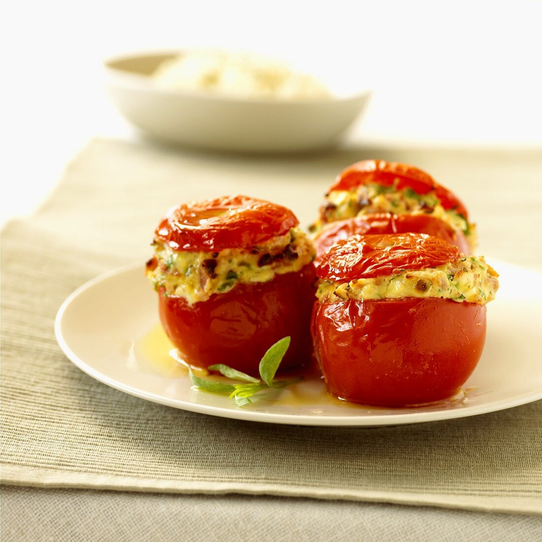 Three tomatoes stuffed with cheese, bacon and leeks