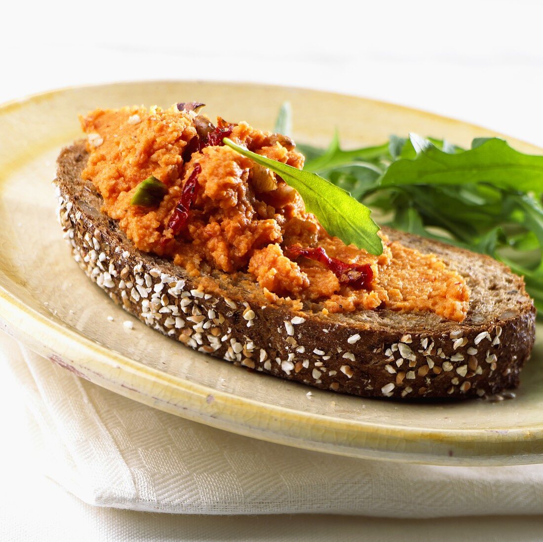 Pumpkin & nut spread on a slice of wholemeal bread with rocket