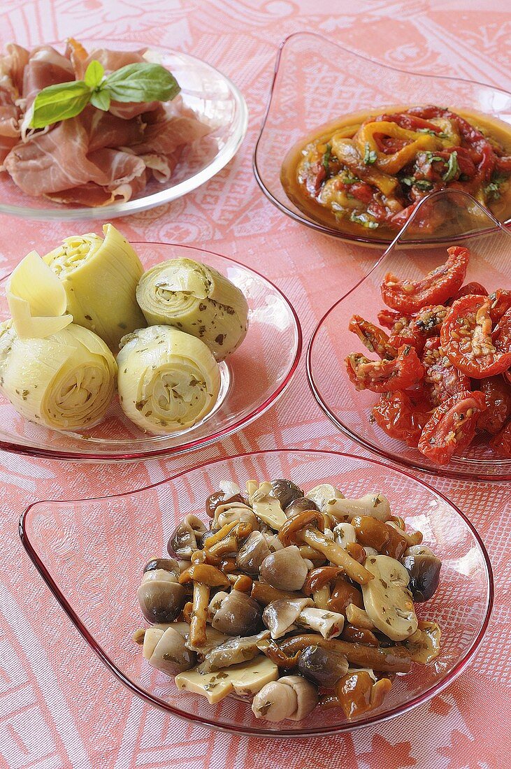 Assorted antipasti on glass plates